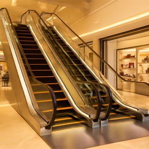 تصویر با وضوح بالا از طراحی لوکس پله برقی در یک مرکز خرید، شامل پلههای سیاه و نورپردازی LED زرد، با نردههای استیل براق و محیط مدرن فروشگاهی.