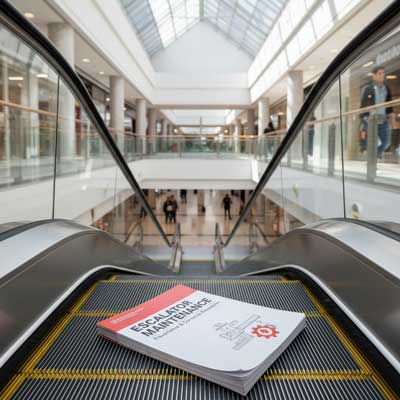 یک عکس از پله‌برقی با دفترچه سرویس نگهداری که روی پله‌ها قرار دارد.