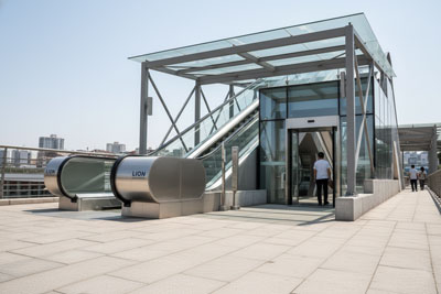 پله‌ برقی بیرونی برند Line Escalator در ورودی ایستگاه مترو با سازه استیل ضدزنگ و سقف شفاف محافظ
