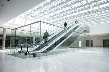 پله برقی شیشه ای تمام شفاف در لابی مدرن
