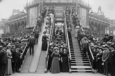 تصویری از دو پله برقی اولیه متعلق به جسی رنو و چارلز سیبرگر در نمایشگاه پاریس ۱۹۰۰ که رقابت آن‌ها در تاریخچه پله برقی را نشان می‌دهد.